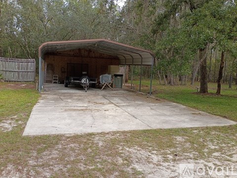 A car is parked in a garage with a metal roof.