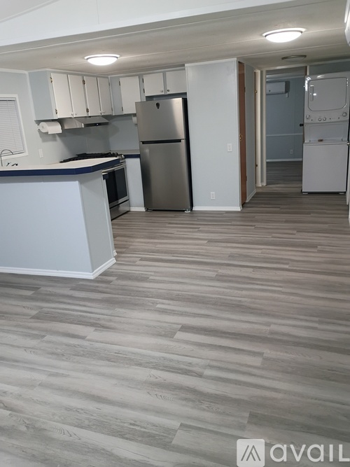A kitchen with a white counter and a stainless steel refrigerator.