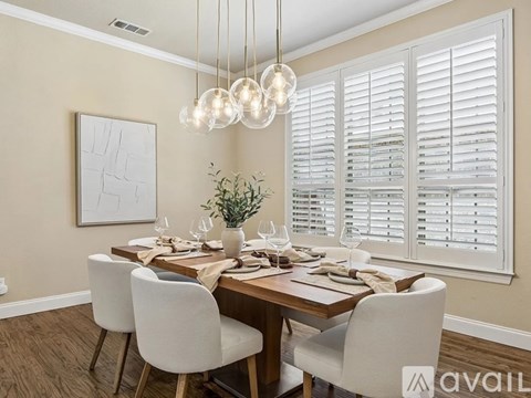 A dining room with a wooden table set for four.