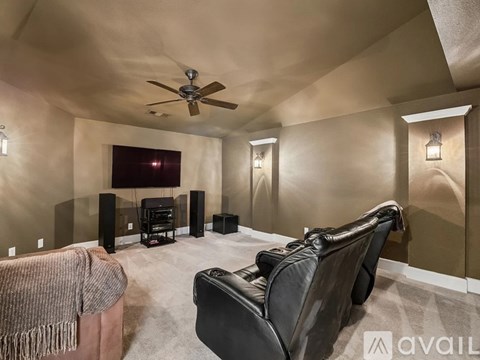 A living room with a black leather chair and a flat screen TV.