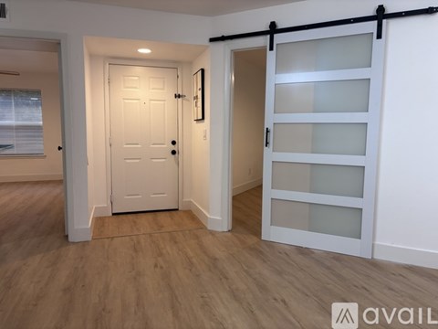 A white door is in a room with a wooden floor.