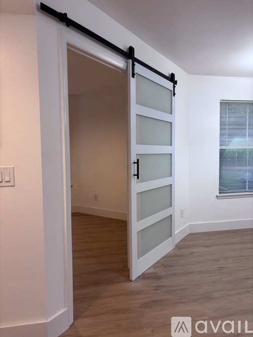A white door with a black handle and a window in the background.