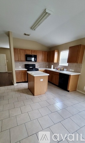 A kitchen with a black microwave and stove.