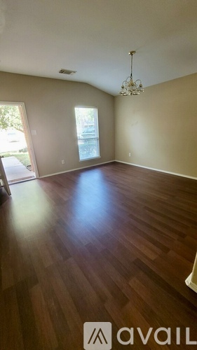 A room with wooden floors and a chandelier.