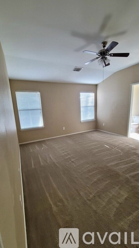 A room with a ceiling fan and a carpeted floor.