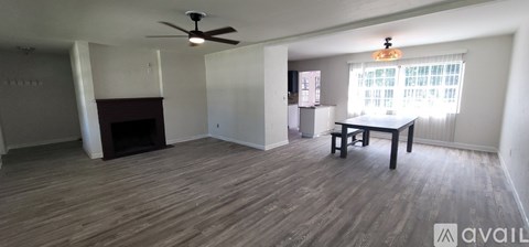 A living room with a fireplace and a dining table.