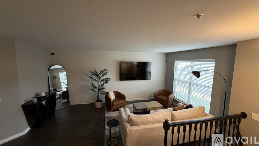 A living room with a couch, chair, and a plant.