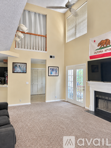 A living room with a fireplace and a California Republic flag.