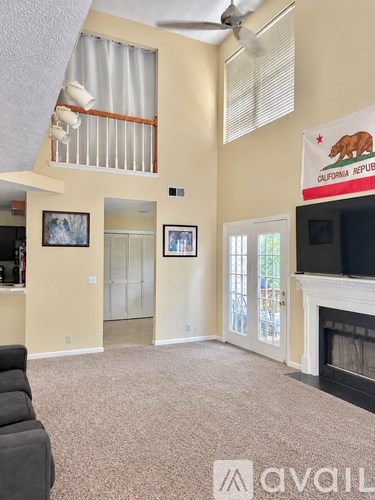 A living room with a fireplace and a California Republic flag.