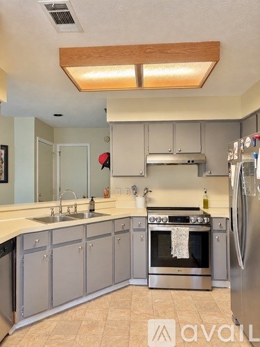 A kitchen with a stove top oven and a refrigerator.