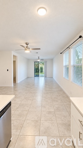A kitchen with white cabinets and a tiled floor.