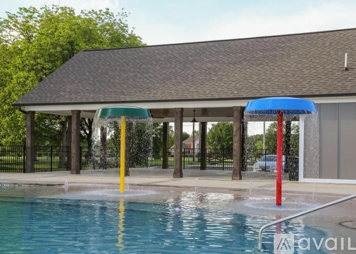 A pool with a water slide and a pavilion.