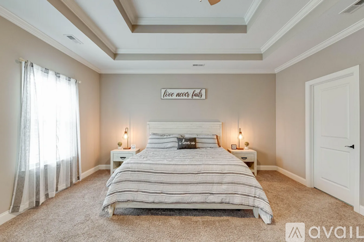 A bedroom with a large bed and a ceiling fan.
