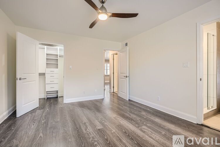 A spacious room with a ceiling fan and wooden flooring.