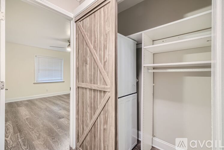 A wooden door is open to reveal a white closet.