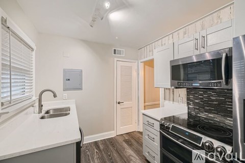 A kitchen with a stove top oven and a sink.
