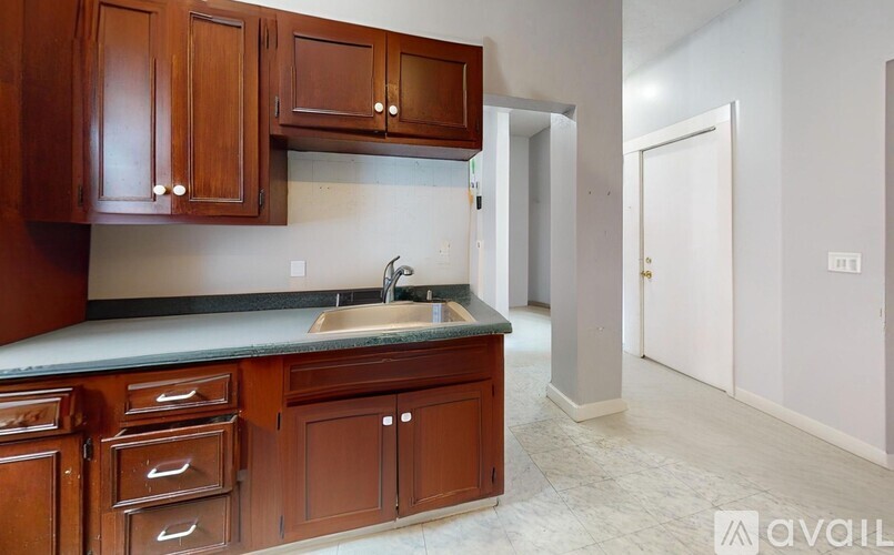 A kitchen with wooden cabinets and a marble countertop.