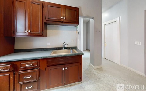 A kitchen with wooden cabinets and a marble countertop.