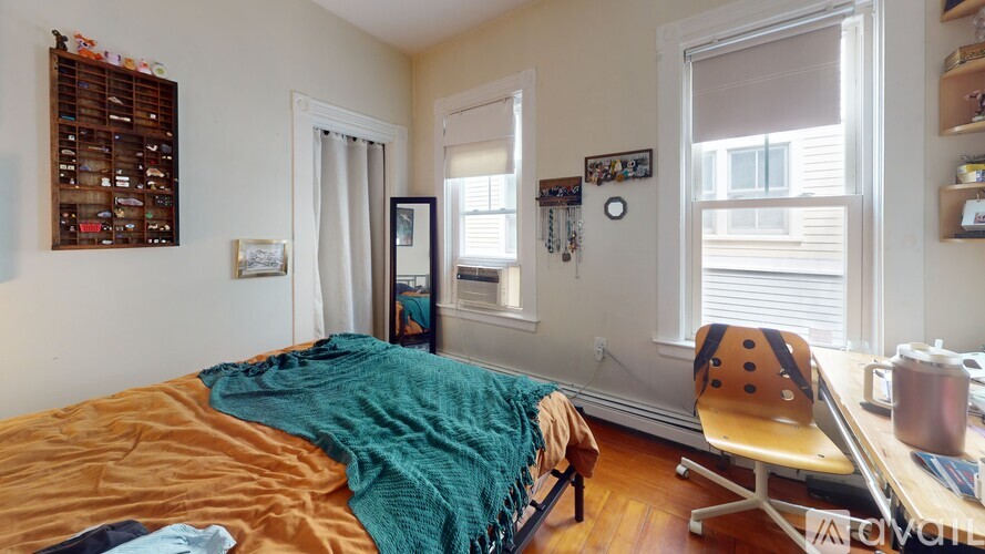 A bedroom with a bed, desk, and chair.