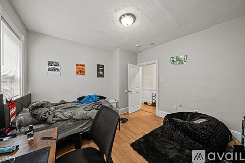 A bedroom with a bed, chair, and a sign on the wall.
