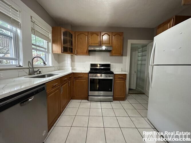 A kitchen with white appliances and brown cabinets.