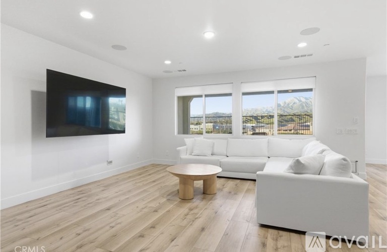 A modern living room with a flat screen TV mounted on the wall.