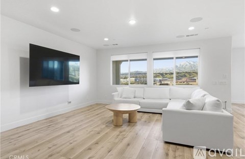 A modern living room with a flat screen TV mounted on the wall.