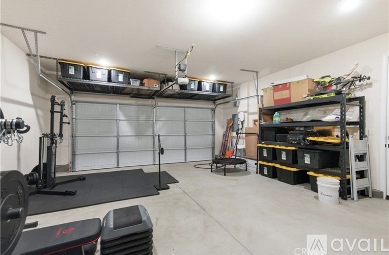 A garage with a gym setup and storage shelves.