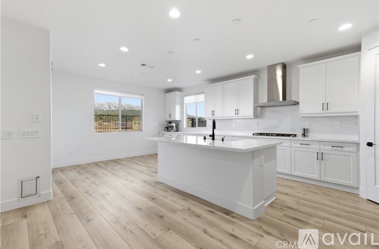 A modern kitchen with white cabinets and a large island.