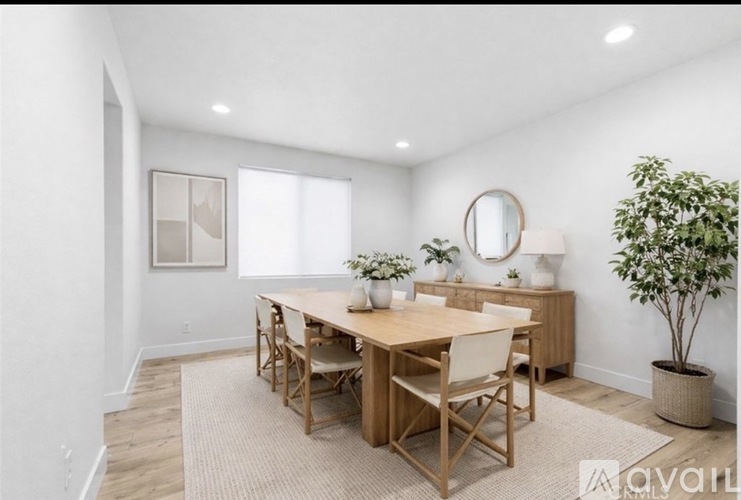 A dining room with a wooden table and chairs.