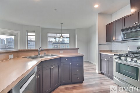 A kitchen with dark brown cabinets and stainless steel appliances.