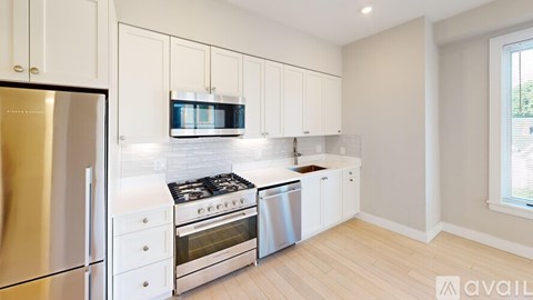 A kitchen with white cabinets and stainless steel appliances.