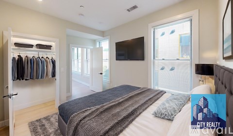 A bedroom with a large bed and a television mounted on the wall.