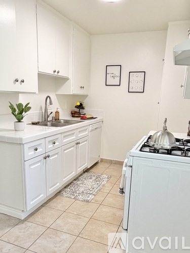 A kitchen with white cabinets and a tiled floor.