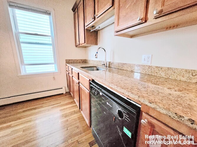 A kitchen with wooden cabinets and a granite countertop.