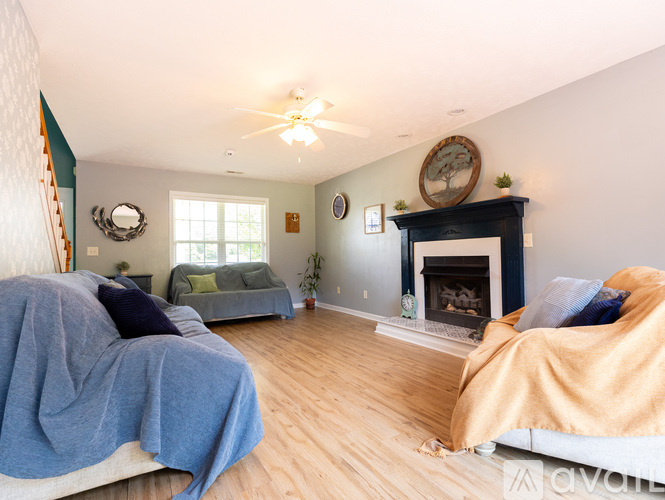 A living room with a fireplace and two couches.