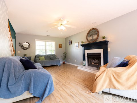 A living room with a fireplace and two couches.