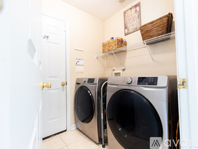 Two front load washing machines in a small laundry room.