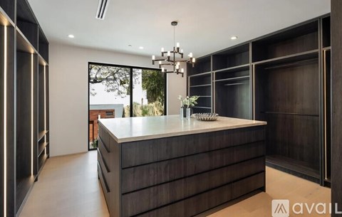 A modern kitchen with dark wood cabinets and a white countertop.