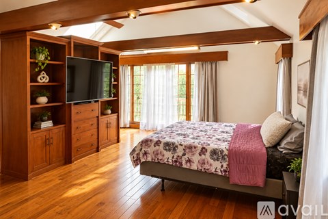 A bedroom with a bed, a television, and wooden furniture.