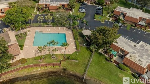 An aerial view of a community with a swimming pool and apartment buildings.