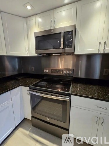 A kitchen with a stove and microwave above it.