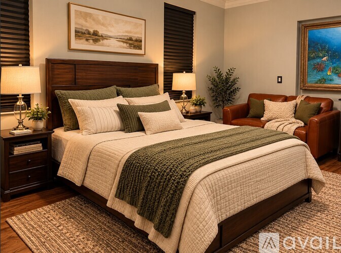 A bedroom with a large bed and a painting on the wall.