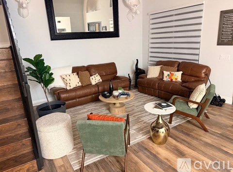 A living room with brown leather couches and a green chair.