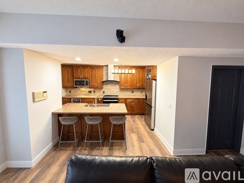 A kitchen with wooden cabinets and a black couch.