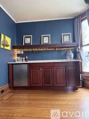 A kitchen island with a fridge and a counter with a vase on it.