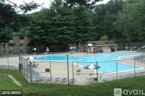 A large outdoor swimming pool surrounded by a fence.