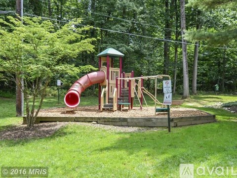 A playground with a red slide and a green roof.