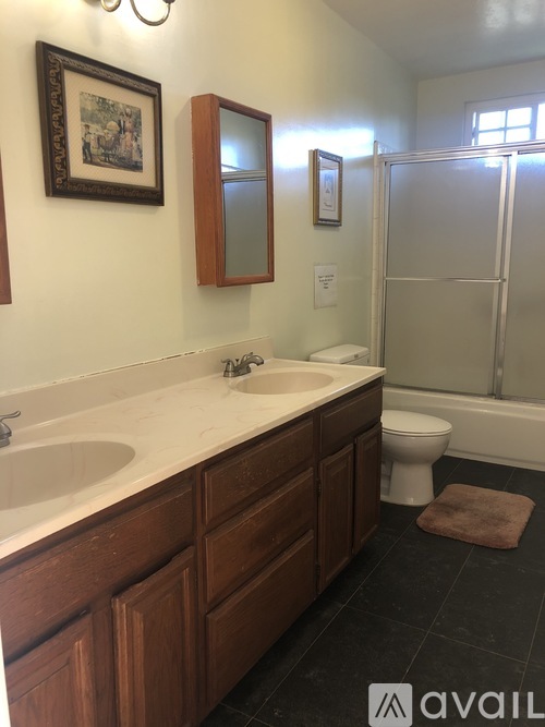 A bathroom with a sink, toilet, and mirror.