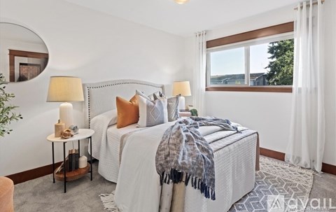 A bedroom with a large bed and a window overlooking the outdoors.